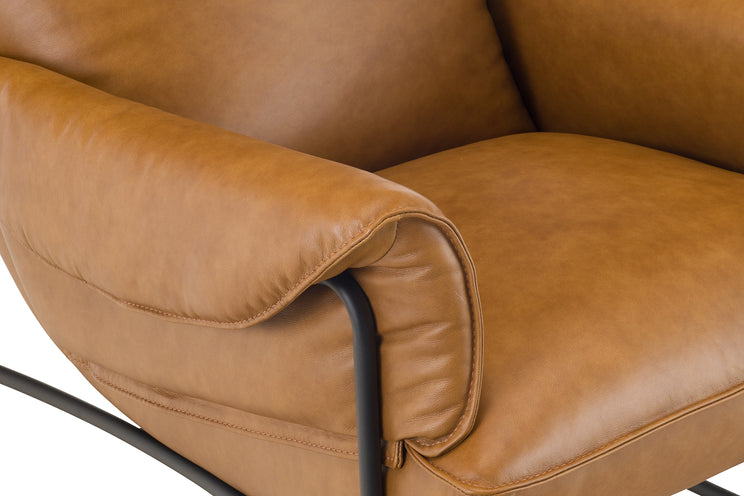 Close-up of a brown leather armchair with visible stitching